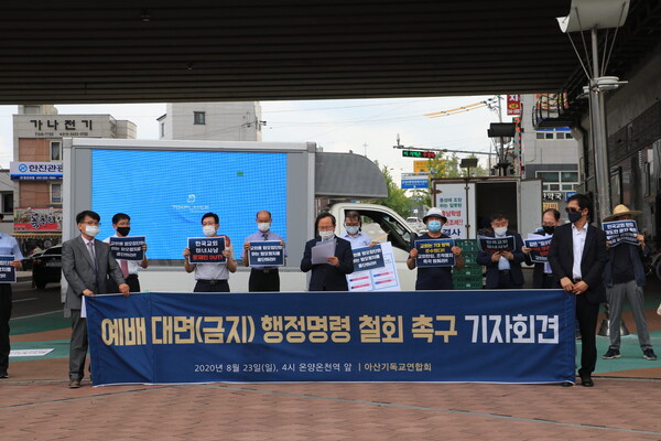 아산시기독교연합회 임원들이 기자회견에서 반대 피켓을 들고 있다.
