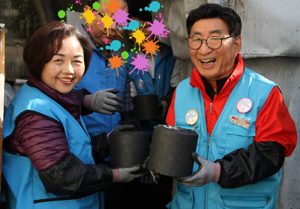 김영기 장로가 아내 조영순 장로와 연탄 봉사 중에 환하게 웃고 있다.