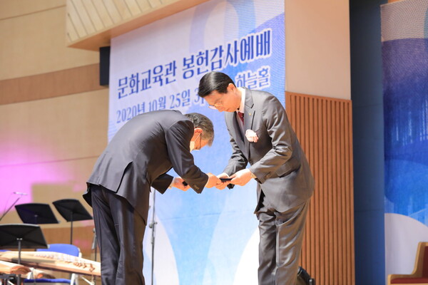 관리부장 김 농 장로가 구용걸 감리사에게 봉헌위임장을 건네고 있다.