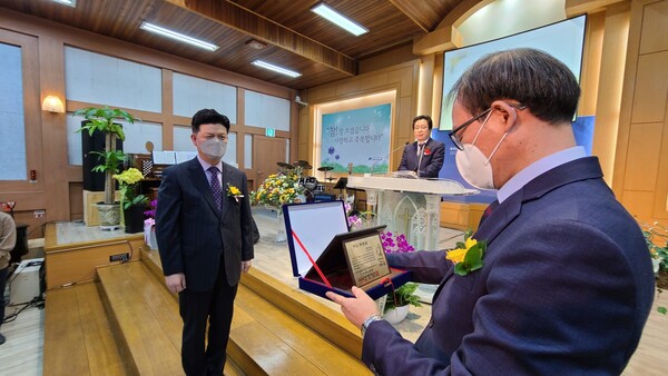 조장현 목사가 취임 축하패를 전달받고 있다.