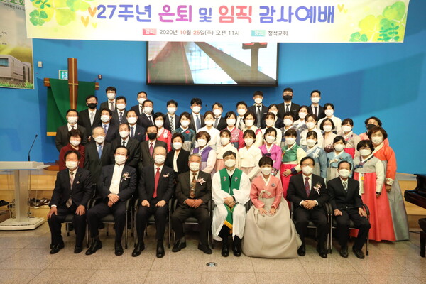 김형일 위임목사와 임직자, 은퇴자, 안수위원이 함께 단체사진을 촬영하고 있다.