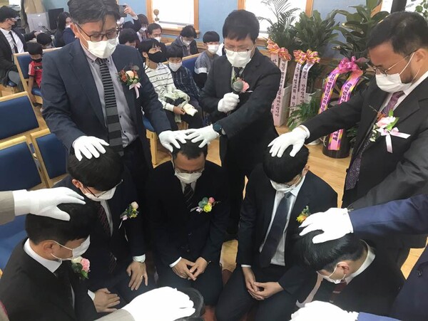 박형섭 목사(사진 중앙)가 안수집사 임직자들에게 안수 기도를 하고 있다.
