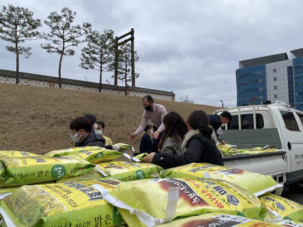 당진시 공무원들과 성도들이 쌀이 필요한 곳에 직접 쌀을 옮기고 있다.