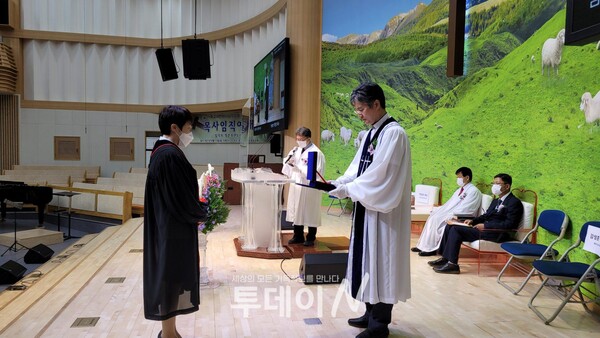 기하성 제주지방회 회장 차진호 목사(사진 오른쪽)가 정춘자 목사에게 목사 임직패를 전달하고 있다.