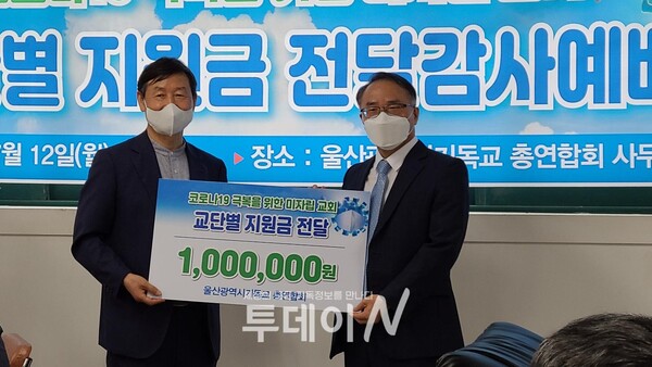 이우탁 회장이 김홍진 노회장(예장합동 남울산노회)에게  지원금을 전달하고 있다.