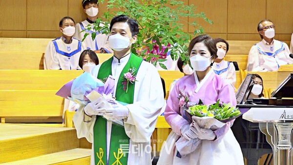 박상현 목사와 이지현 사모가 위임 축하 꽃다발을 들고 한소망교회 김준동&정희경 집사의 축가 '은혜'를 듣고있다.