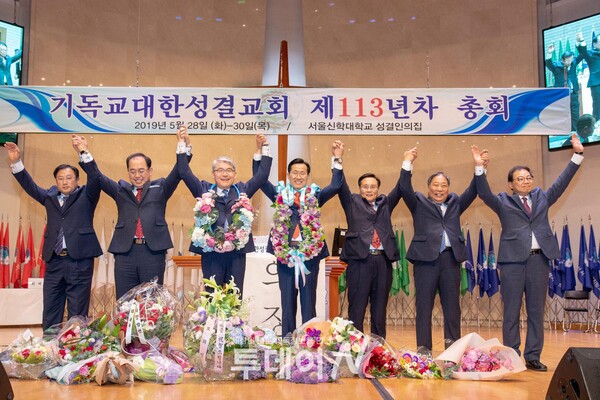 기독교대한성결교회 제113년차 총회에서 류정호 총회장이 취임한 임원들과 손을들어 인사하고 있다.