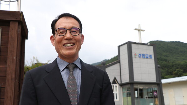 성법교회 이승웅 담임목사가 교회 앞에서 환하게 웃고 있다.