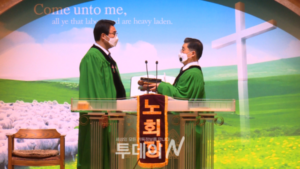직전 노회장 김영호 목사(오른쪽)가 신임 노회장 손석호 목사(왼쪽)에게 성경과 의사봉을 전달하고 있다.