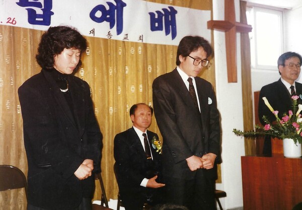 1990년 거창 대동교회 개척예배에서 백용현 목사와 염민자 사모가 단상 앞에 서 있다.