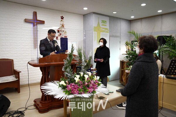 박노현 목사가 은퇴하는 김윤복 권사에게 은퇴패를 증정하는 모습