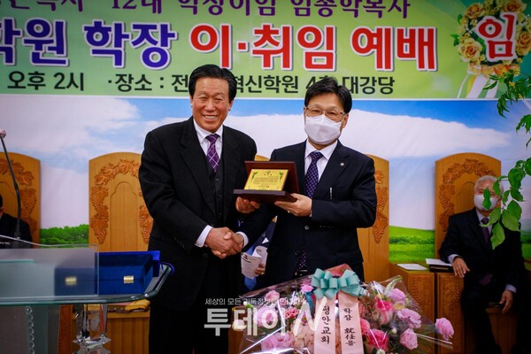 전북개혁신학원 이사장 김황융 목사가 신임 학장 이경근 목사에게 취임패를 전달하고 함께 기념 사진을 촬영하고 있다.