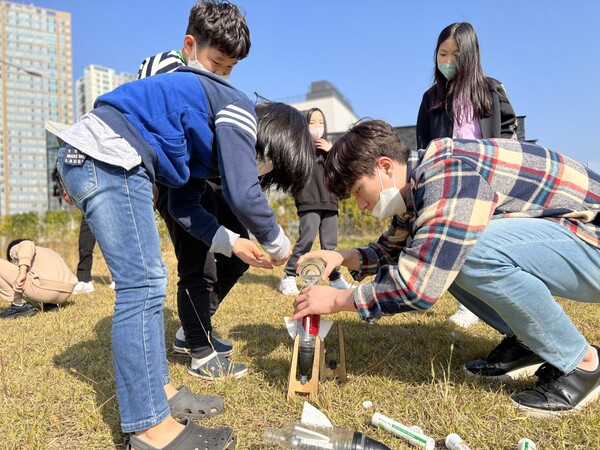‘하쏘로’(하담 아이들이 쏘아 올린 작은 로켓) 프로젝트에 참여한 학생들이 학교 앞 공원에서 선생님과 물로켓을 쏘아 올리기 위한 준비 작업을 하고 있다. @출처=글로벌하담기독학교