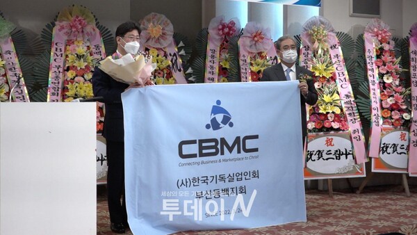 CBMC 김영구 중앙회장과 부산 동백지회 정동수 회장이 지회기를 들고 포즈를 취하고 있다.