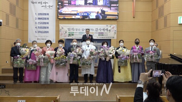 부산대흥교회 임직자들이 나와 꽃다발과 함께 기념사진을 찍고 있다.