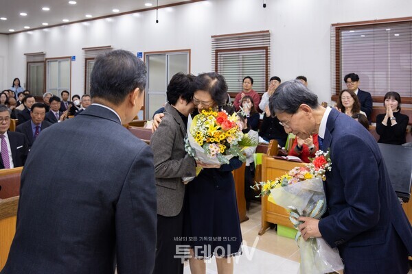 성도들이 홍창민 원로목사 부부에게 꽃다발을 건네며 지난 23년의 헌신에 대한 감사와 아쉬움을 함께 전하고 있다.