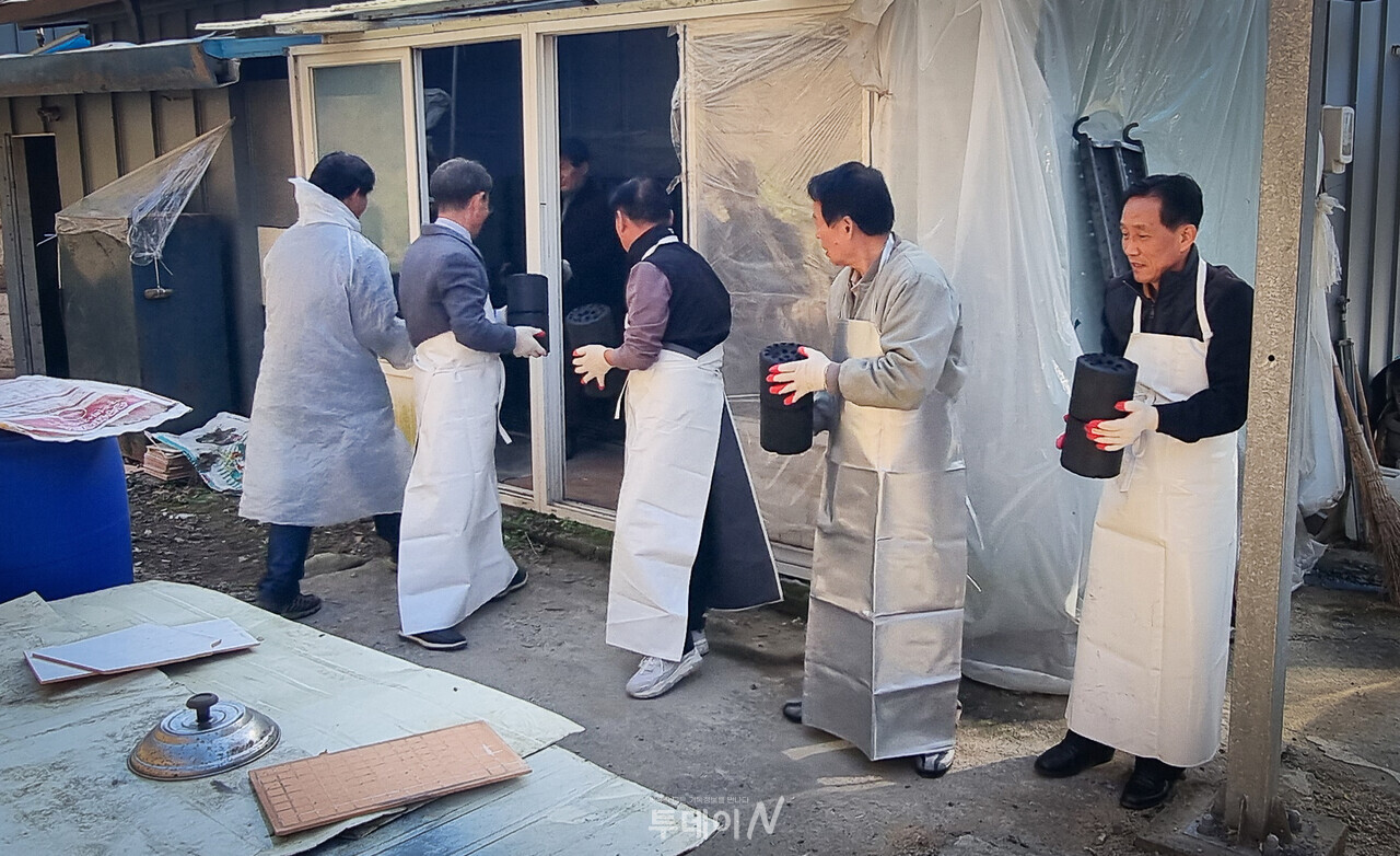 연탄 나눔 사역에 참여한 충주시장로회 임원들이 연탄을 나르고 있다