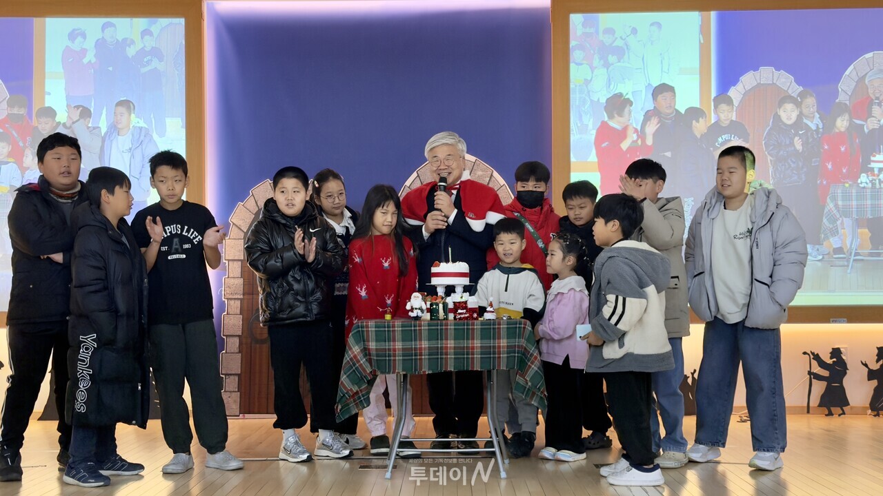 이국진 목사(예수비전교회)와 아이들이 케이크의 촛불을 끄고 예수님의 탄생을 축하하고 있다.
